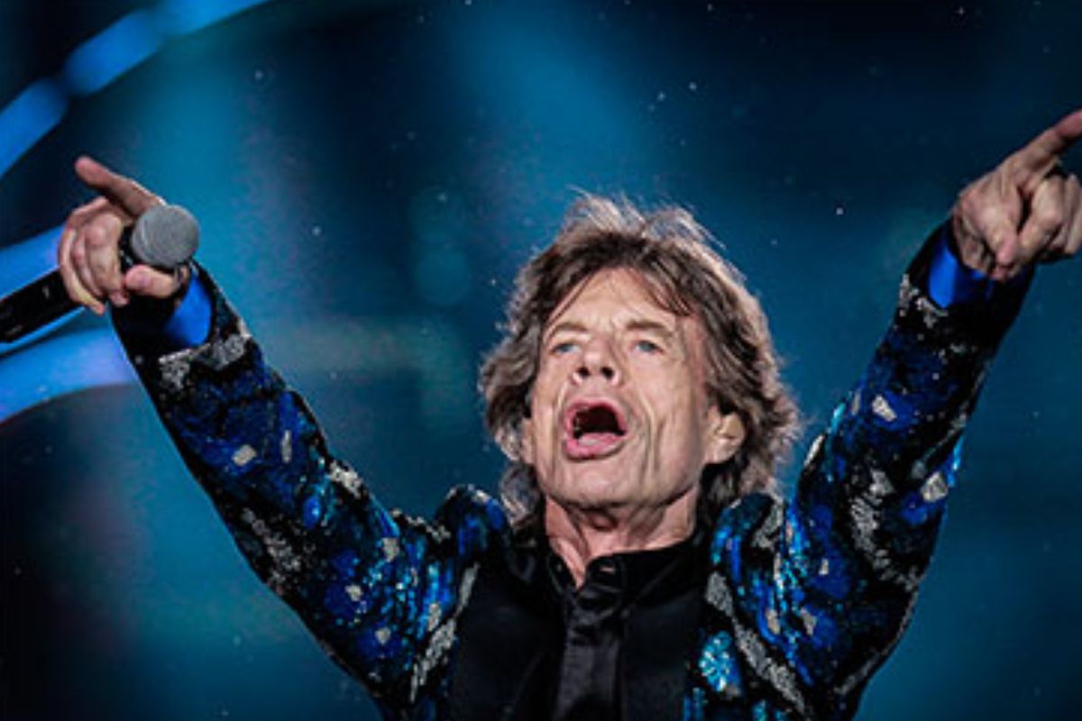 Mick Jagger no palco, com os braços para o alto