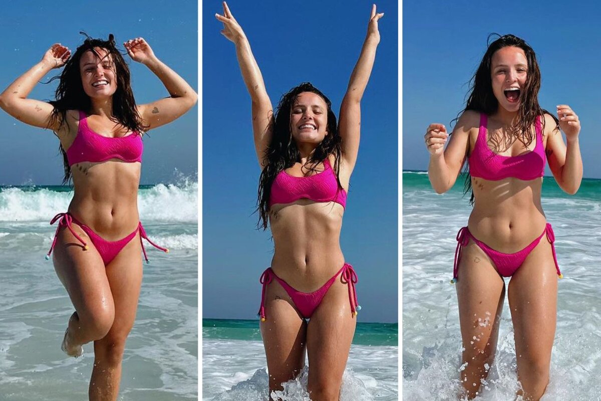 Larissa Manoela de biquíni rosa no mar, comemorando