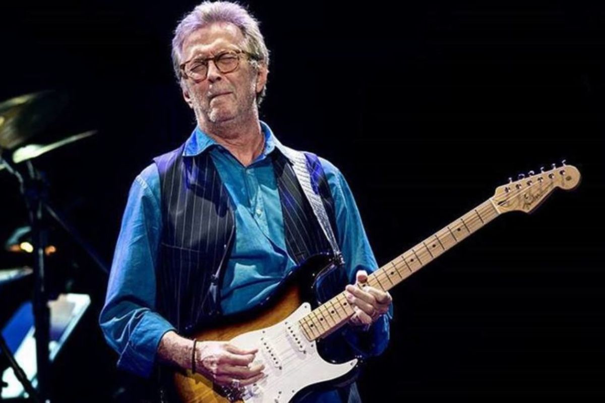 Eric Clapton tocando no palco, com olhos fechados