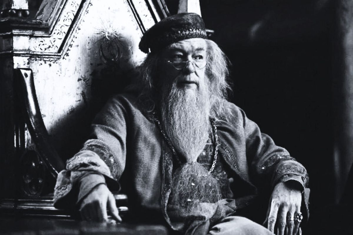 Michael Gambon, intérprete de Dumbledore, de Harry Potter, sentado em cena do filme