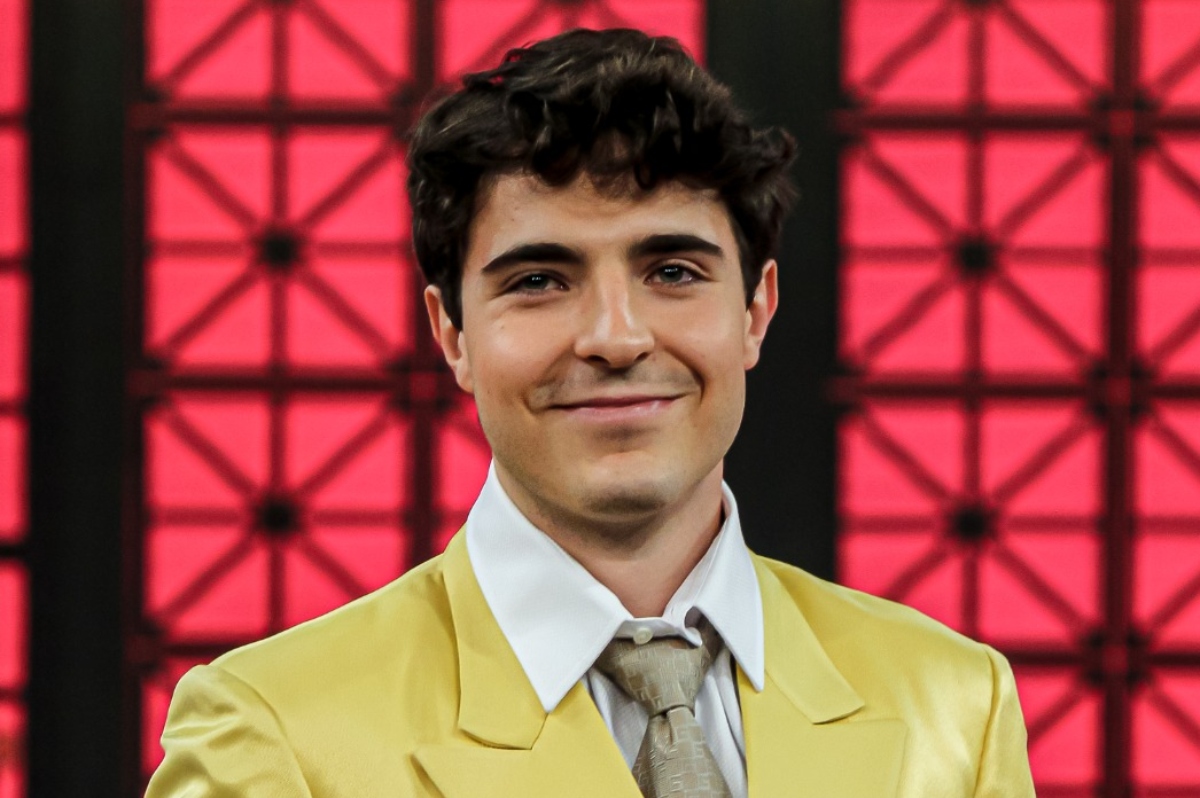 João Liberato de terno amarelo e gravata bege, sorrindo