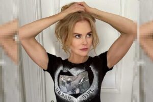 Nicole Kidman de camiseta preta, segurando o cabelo