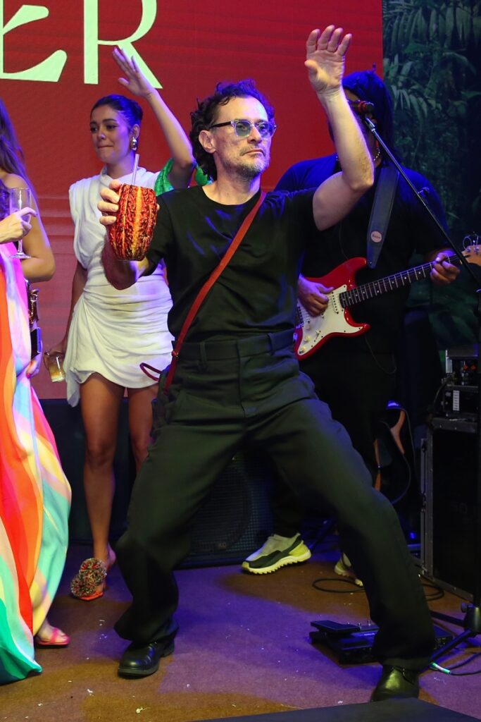 Enrique Diaz dançando, de roupa preta e óculos escuros 