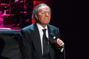 Julio Iglesias de terno preto, cantando