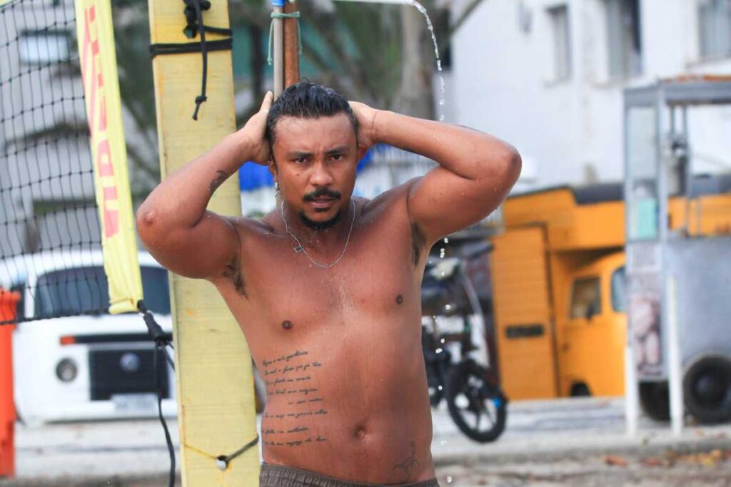 Xamã tomando ducha na praia da Barra da Tijuca