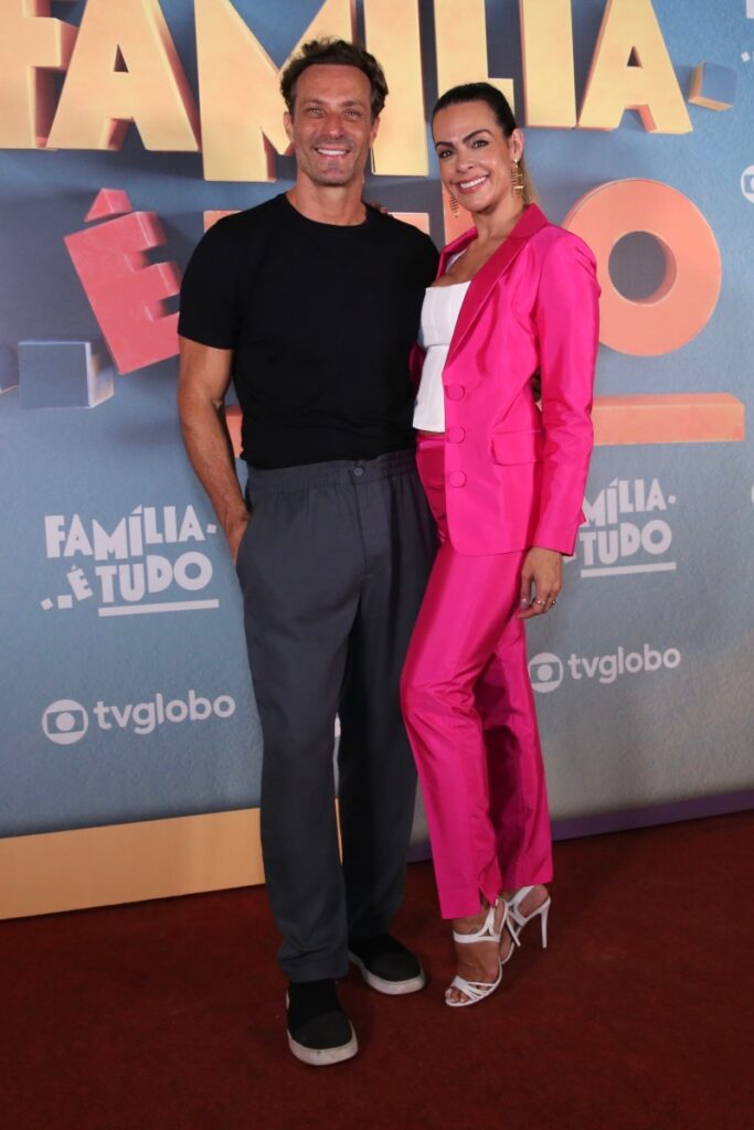 Fernando Pavão de calça cinza e camisa preta ao lado de Lívia Rossi, na festa de lançamento da novela Família é Tudo 