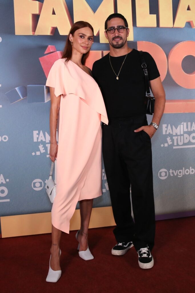 Thaila Ayala de vestido coral claro abraçada a Renato Góes, de calça e camisa preta, na festa de lançamento da novela Família é Tudo 