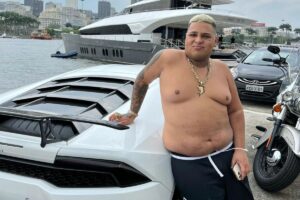 MC Ryan SP ao lado de carro de luxo