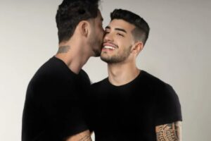 Rico Melquiades beijando a bochecha de Matheus Freire