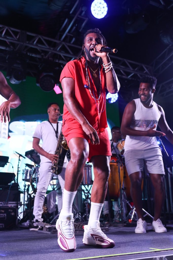 Beto Jamaica de bermuda e camisa vermelha, cantando e dançando