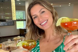 Gisele Bündchen sorri com drinques na mão
