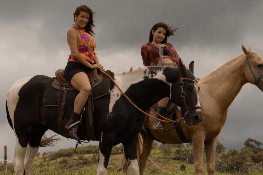 Jaquelline montando o cavalo Colorado com a filha Bella
