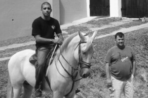 Pedro Scooby montando em cavalo ao lado do pai