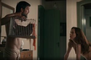 Renascer - Egídio (Vladimir Brichta) de cueca, segurando gaiola, de frente para D. Patroa (Camila Morgado)