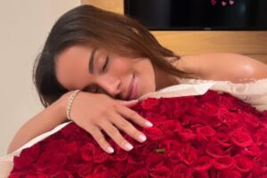 anitta deitada em buquê de flores