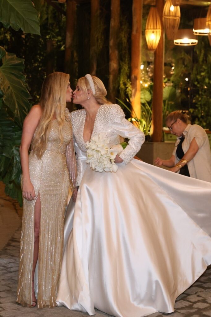 Casamento Monique Evans - Bárbara Evans de vestido longo dourado com fenda, beijando a mãe, vestida de noiva 