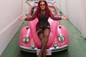 glori groove posando em cima de fusca rosa