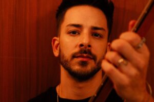 junior lima sentado com violão em mãos