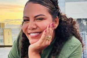 mani reggo posando sorridente com mão no queixo