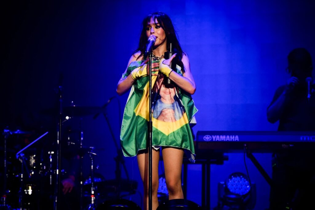 Danna Paola segurando a bandeira do Brasil, cantando