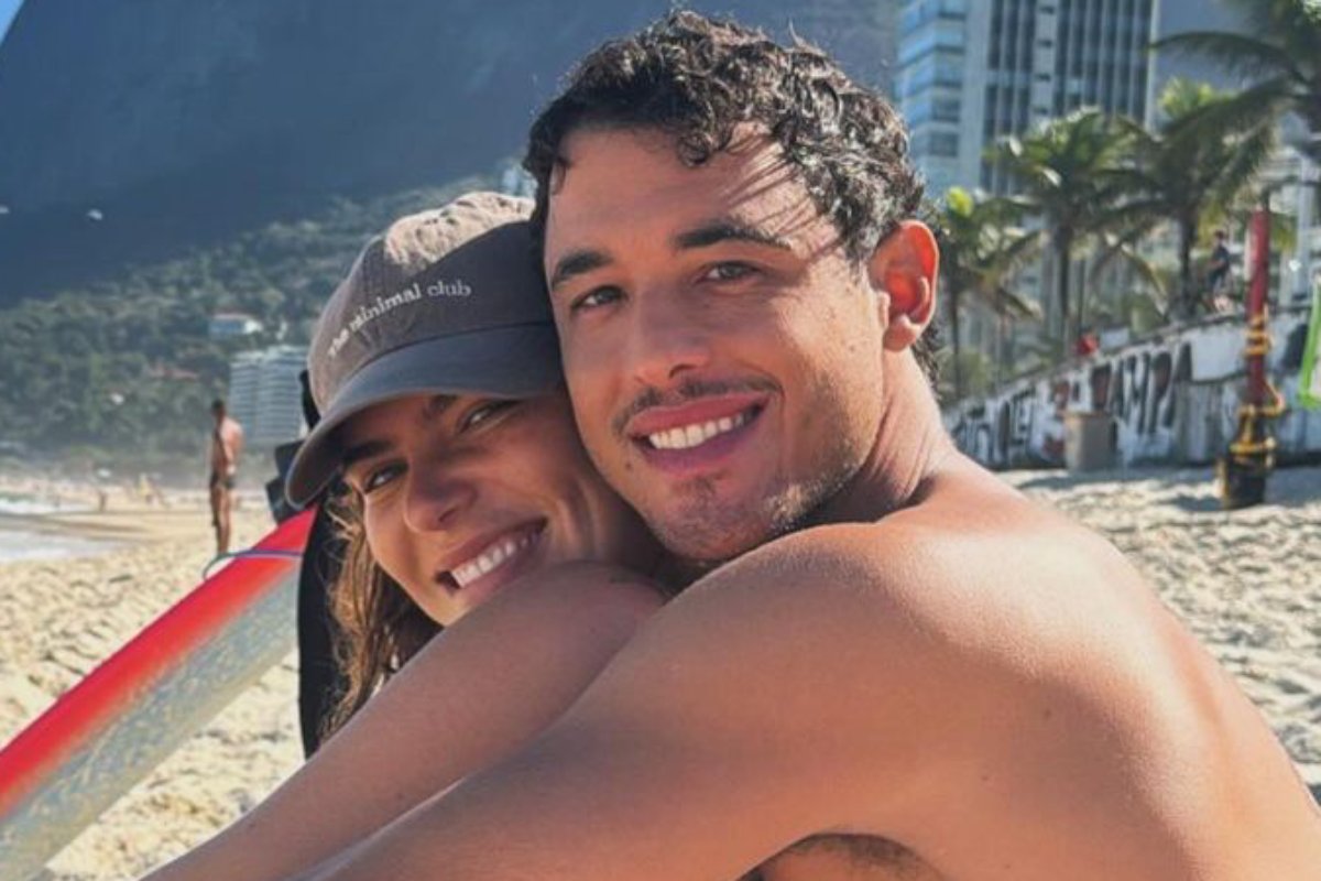 Mariana Goldfarb abraçada com o namorado na praia