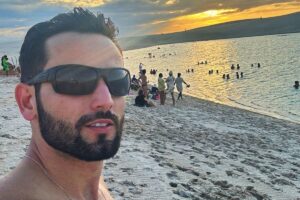 Matteus Amaral de óculos escuros na praia