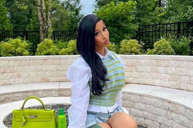 Cardi B sentada no jardim