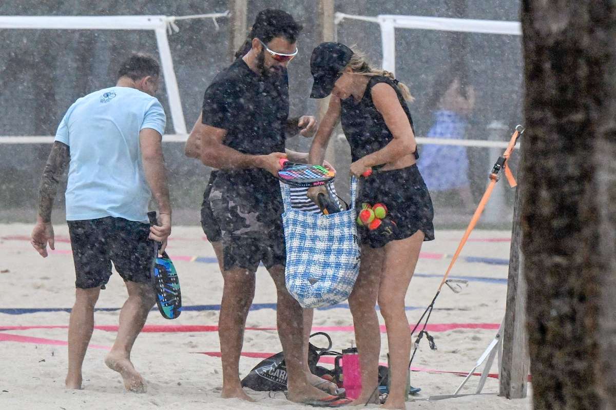 Gisele Bündchen e Joaquim Valente tomando chuva em beach tênis