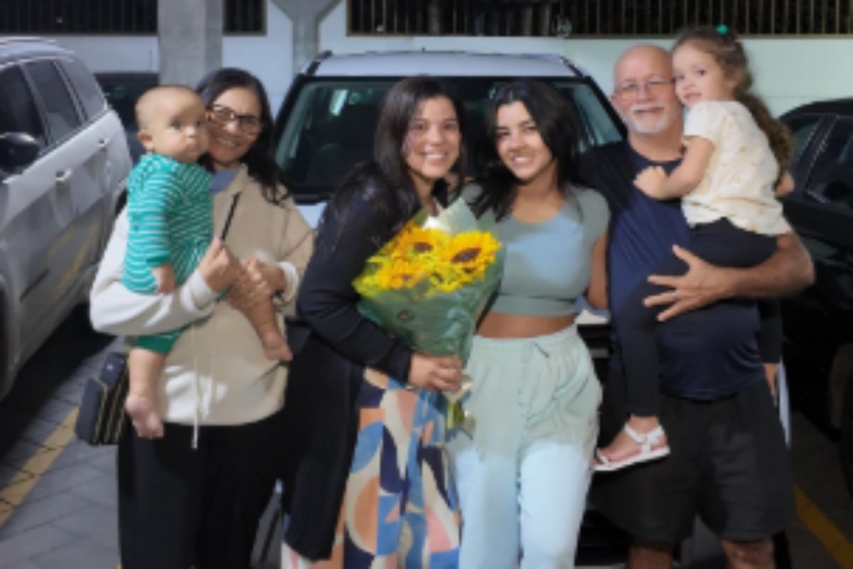 ary mirelle e família poando em frente a carro dado de presente