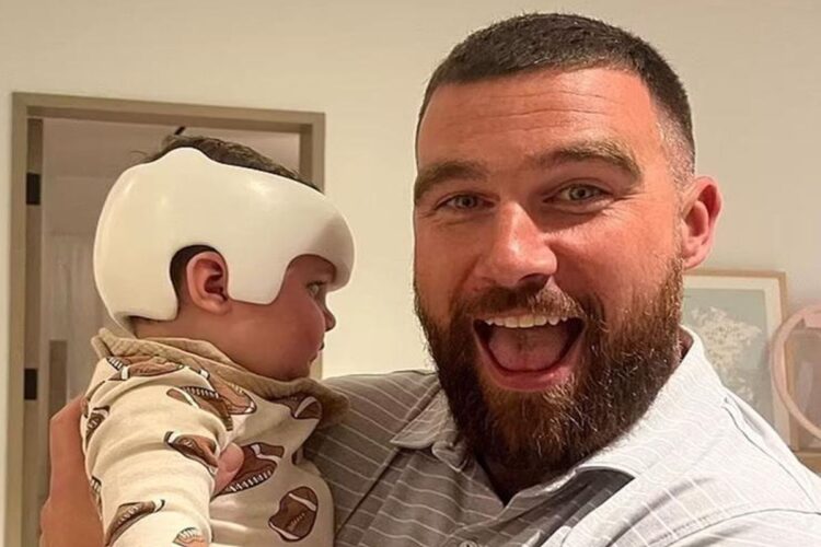 Travis Kelce com um bebê no colo