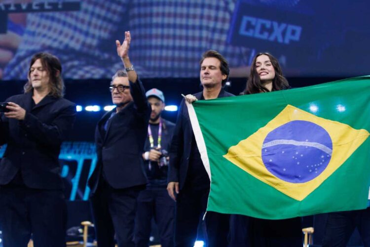 Elenco de de "Bailarina" com bandeira do Brasil em painel na CCXP24