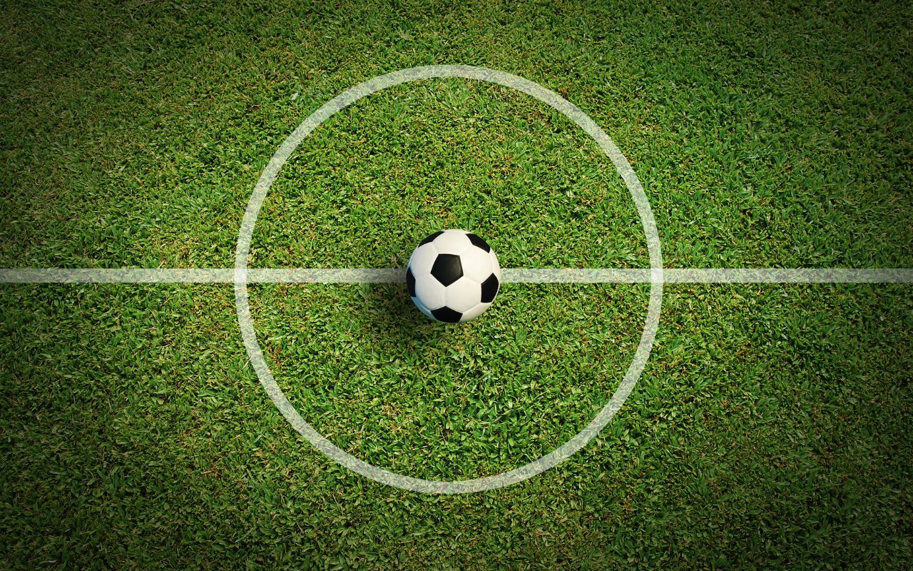 Campo de futebol com bola no centro