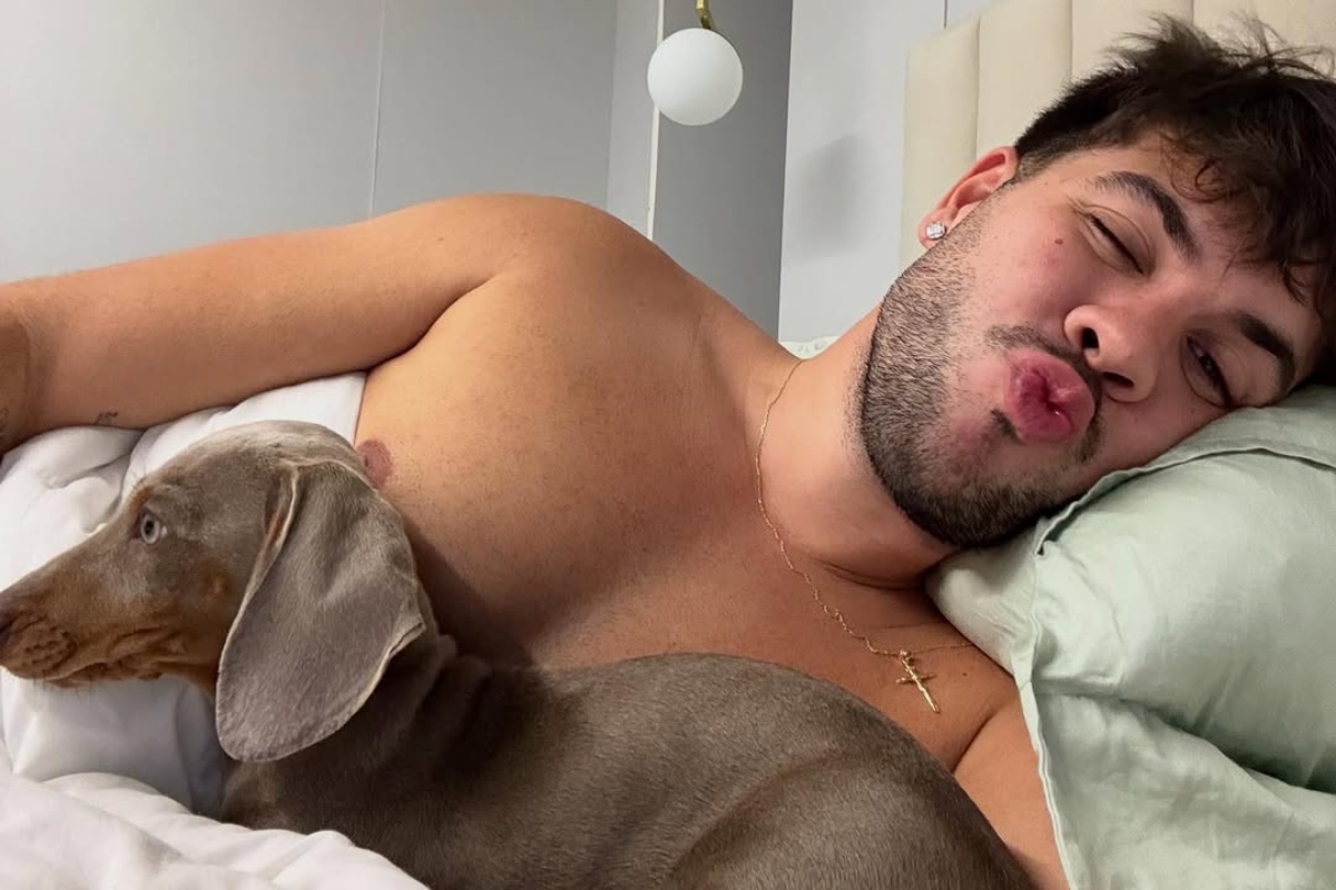 Álvaro e seu pet deitados na cama