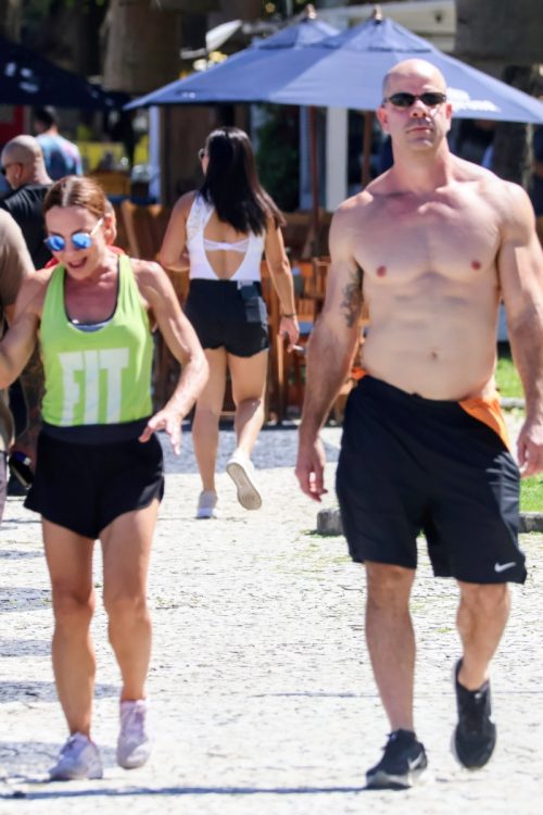 Carla Marins caminha na orla ao lado do marido