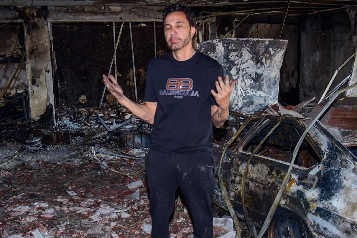 Rogério Alves, pai de MC Gui, nos destroços do incêndio em sua casa